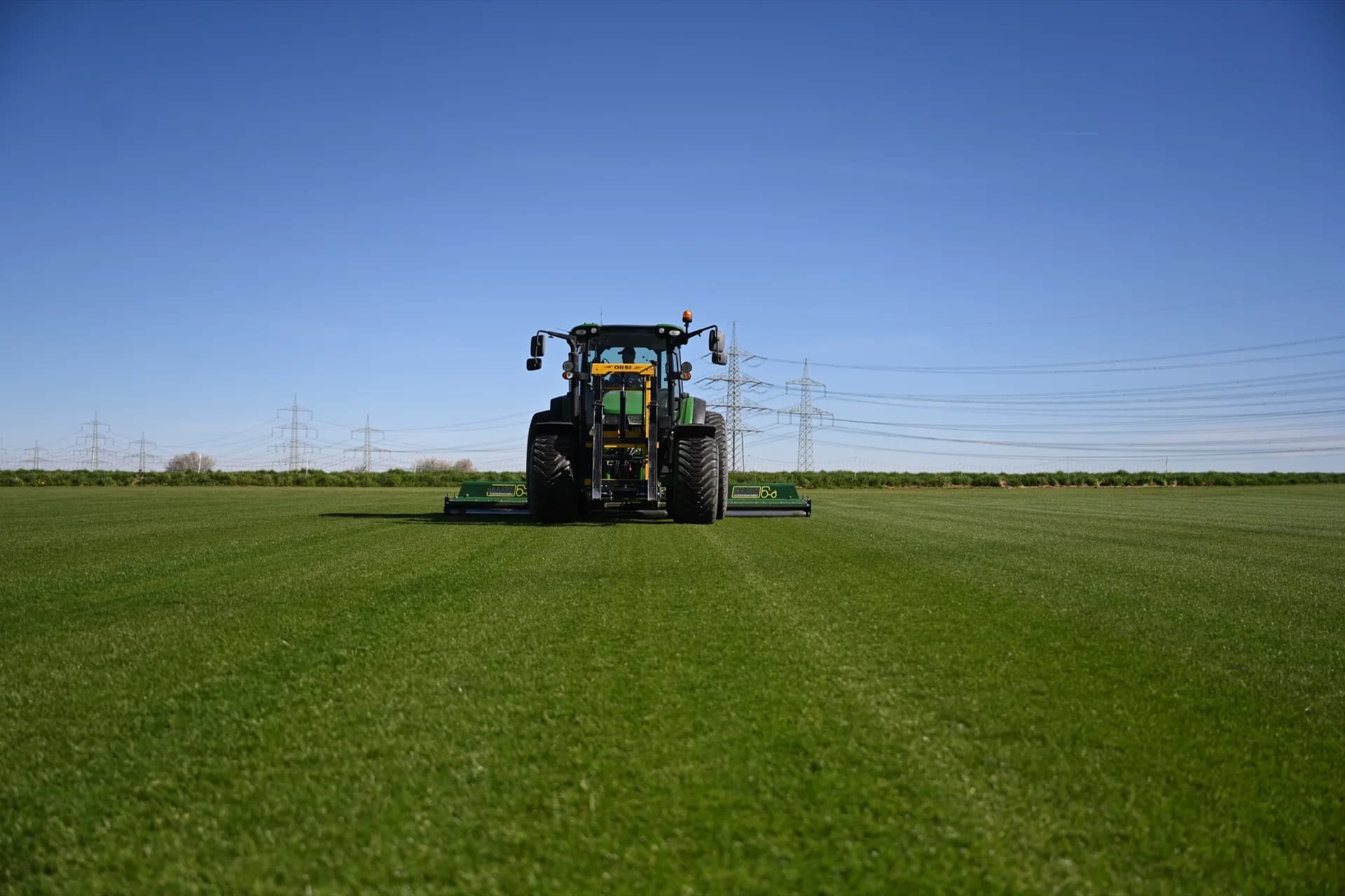 Traktor mäht die Rasenfläche vor der Ernte auf die optimale Höhe